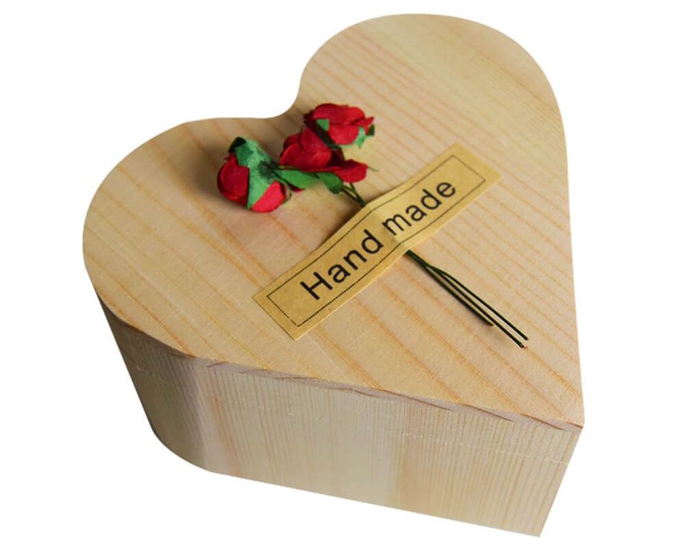rose dans une boîte en bois en forme de coeur